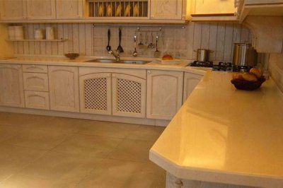 Why should artificial stone be treated with backside glue?